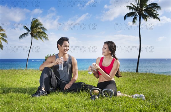 Couple drinking water after exercise at waterfront