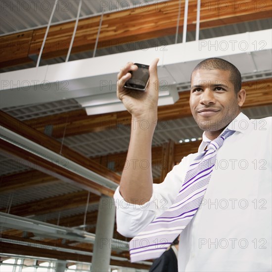 African businessman holding cell phone