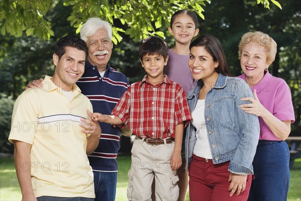 Multi-generational Hispanic family smiling in park