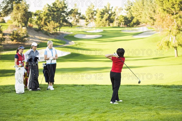 Women playing golf on golf course