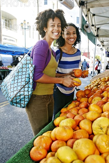 Women shopping together at fruit stand