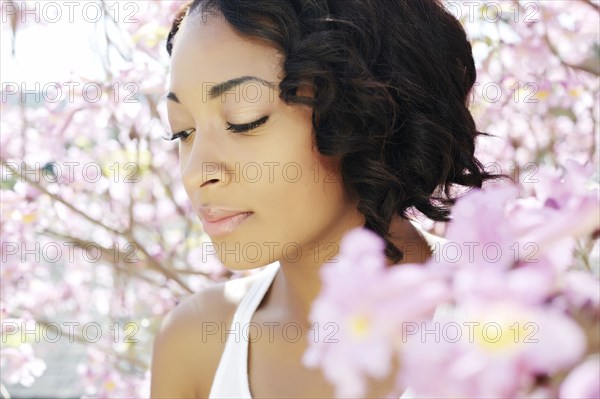 African American woman standing by flowering tree