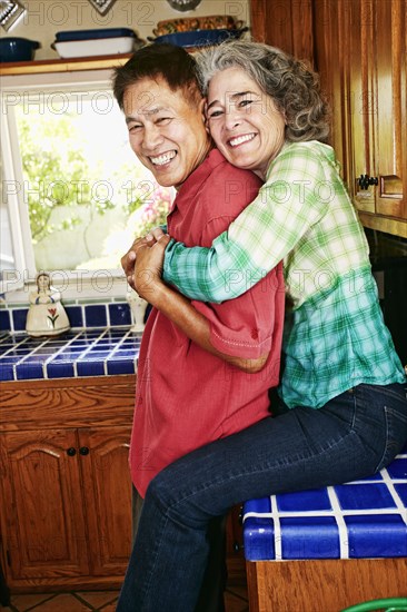 Smiling couple hugging in kitchen