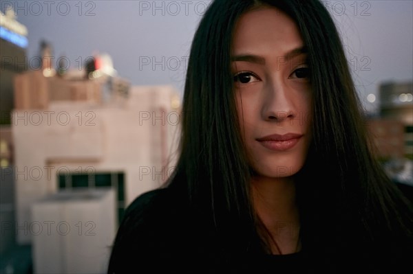 Serious mixed race woman on urban rooftop