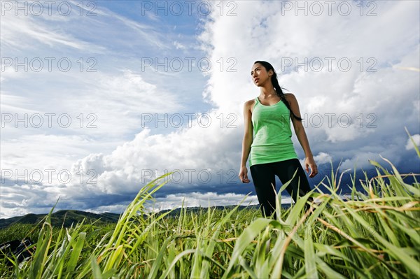 Mixed race athlete standing in rural field