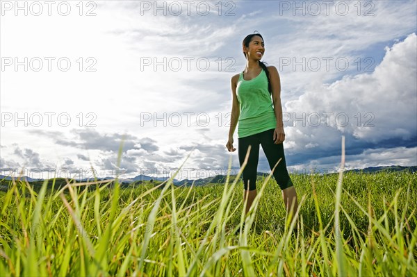 Mixed race athlete standing in rural field