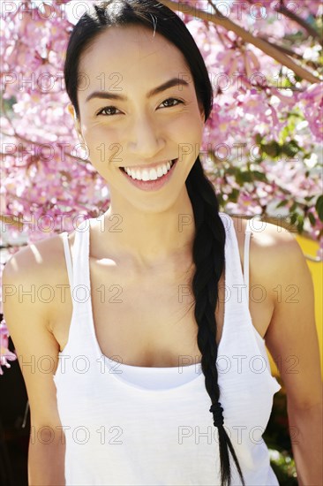 Mixed race woman standing under flowering tree