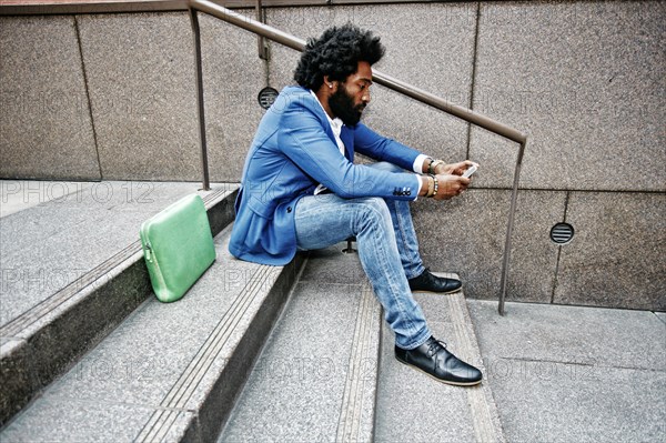 Mixed race businessman using cell phone