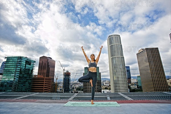 Caucasian woman doing yoga urban rooftop