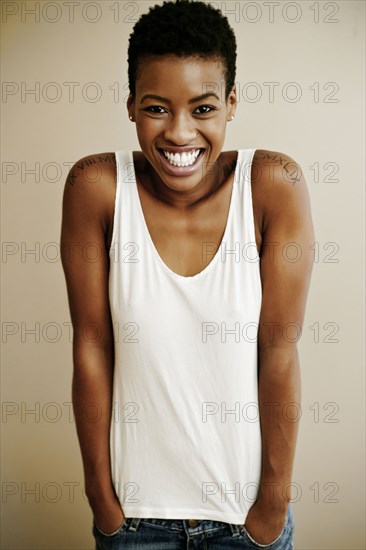 Portrait of smiling Black woman with hands in pockets