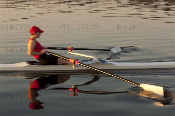 Person rowing sculling boat on river