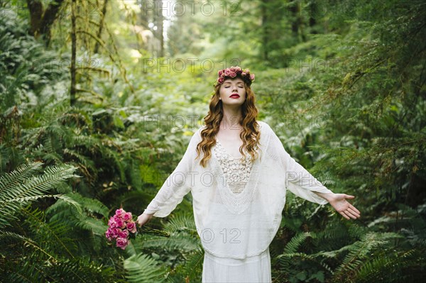 Caucasian woman wearing flower crown in forest