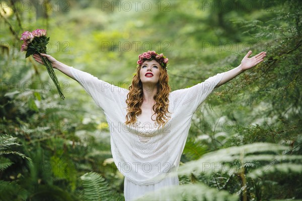 Caucasian woman wearing flower crown in forest
