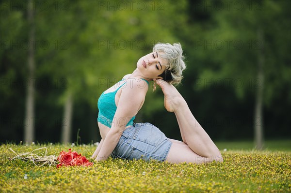 Caucasian woman laying in field arching back