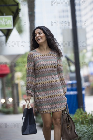 Hispanic woman shopping on city street