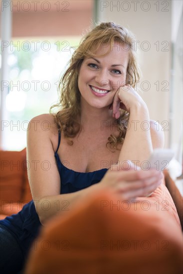 Caucasian woman using cell phone on sofa