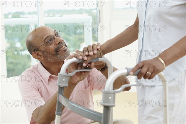 African man encouraging wife using walker