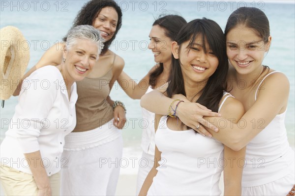 Diverse women standing on beach together