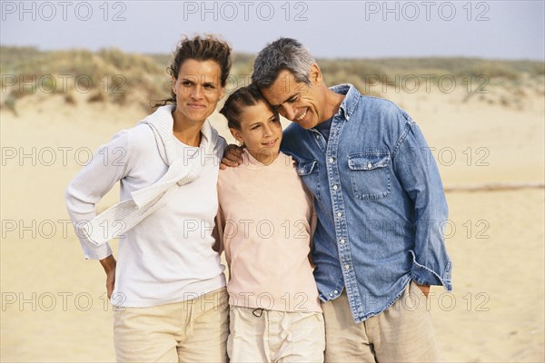 Caucasian family hugging on beach