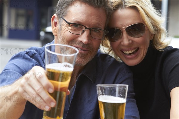 Caucasian couple drinking beer outdoors