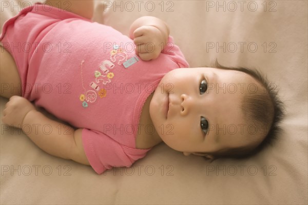 Chinese baby girl laying on bed