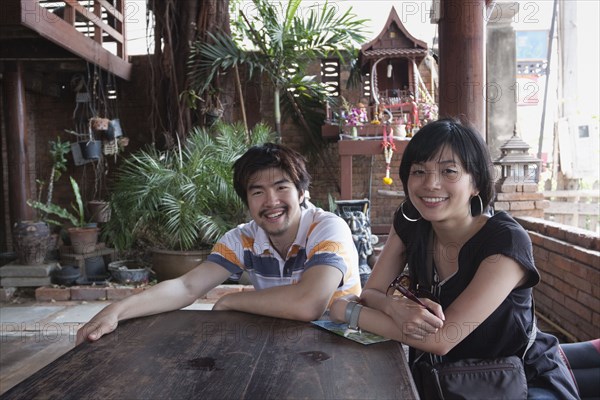 Asian couple sitting at patio table