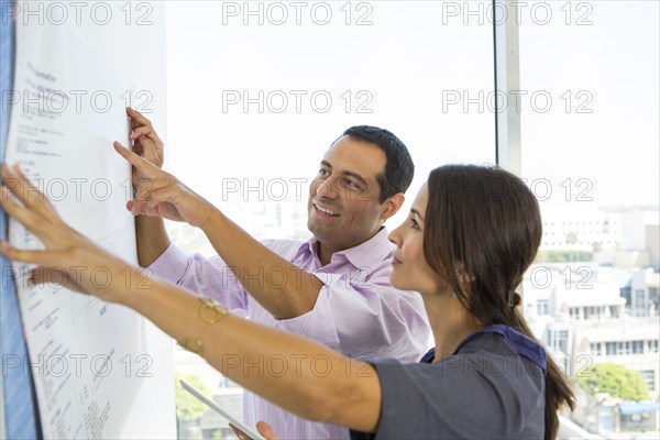 Business people examining blueprints in office