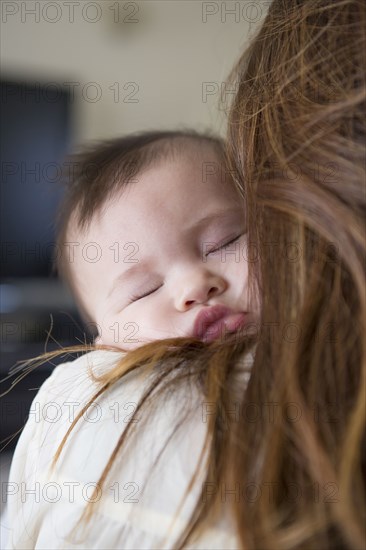 Mother holding sleeping baby girl