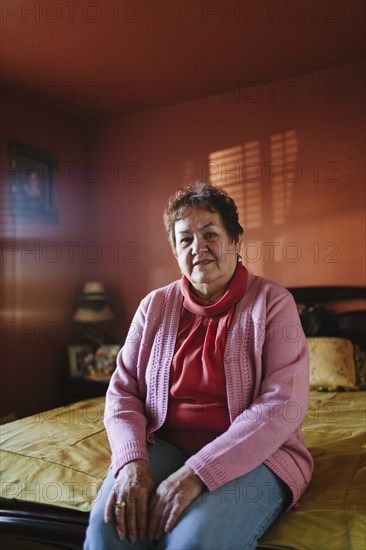 Hispanic Woman Sitting On Bed Photo12 Tetra Images Shestock