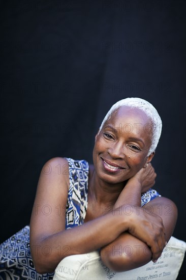 Smiling woman leaning on chair back