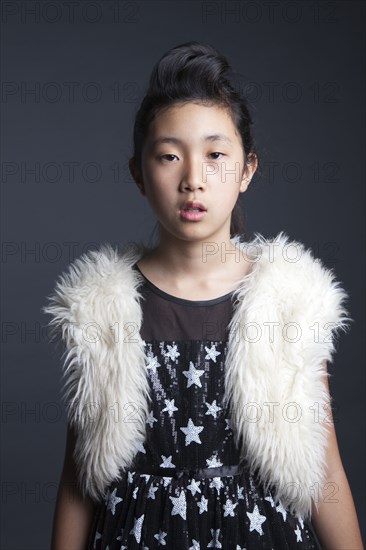 Serious Asian girl wearing furry vest