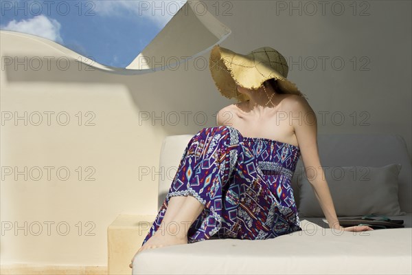 Caucasian woman wearing sun hat in cabana