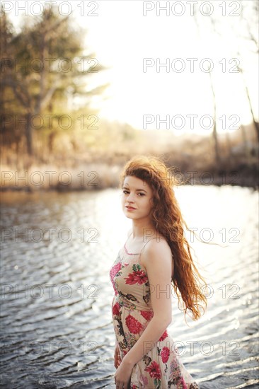 Hispanic woman standing in rural lake