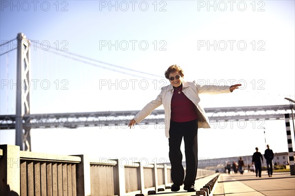 Senior Hispanic woman walking on urban boardwalk