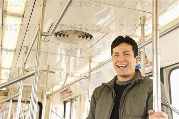 Hispanic man laughing on train