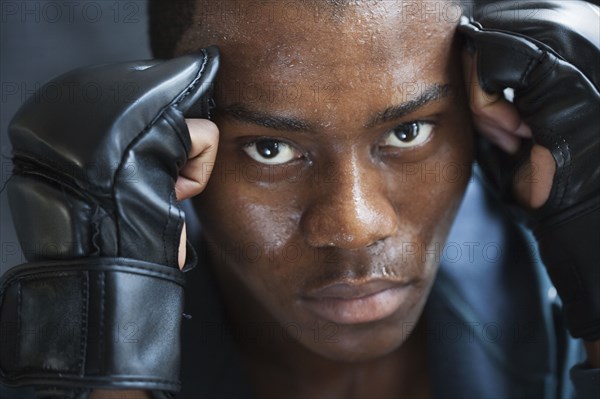 Sweating mixed race man in padded gloves