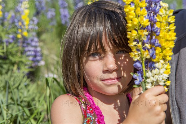 Caucasian girl holding bouquet of wildflowers