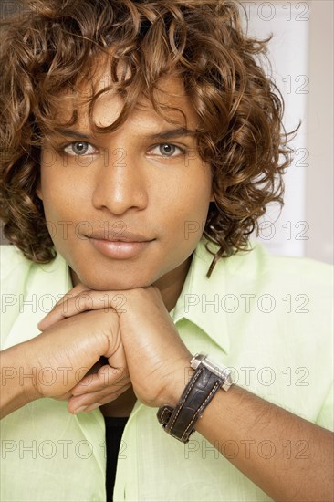 Middle Eastern man resting chin on hands