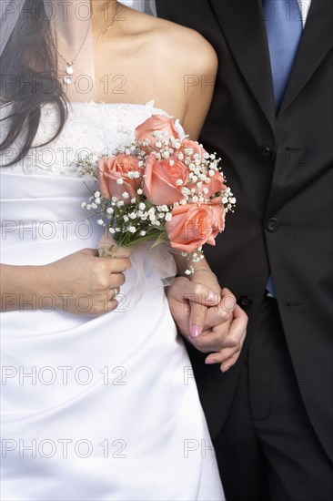 Newlywed couple holding hands