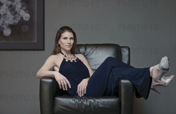 Mixed race woman in evening gown laying in armchair