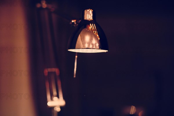 Close up of illuminated desk lamp at night