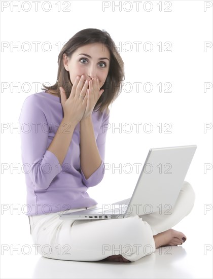 Gasping woman using laptop