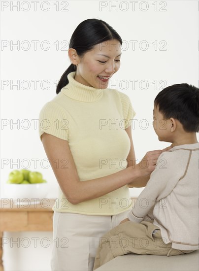 Mother dressing son