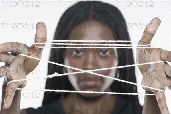 Young woman holding a cat's cradle out to the camera