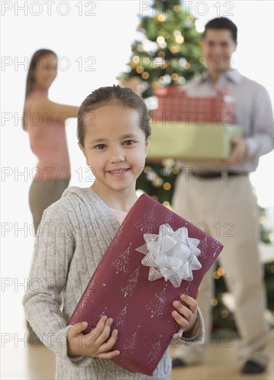 Portrait of Hispanic girl holding Christmas gift