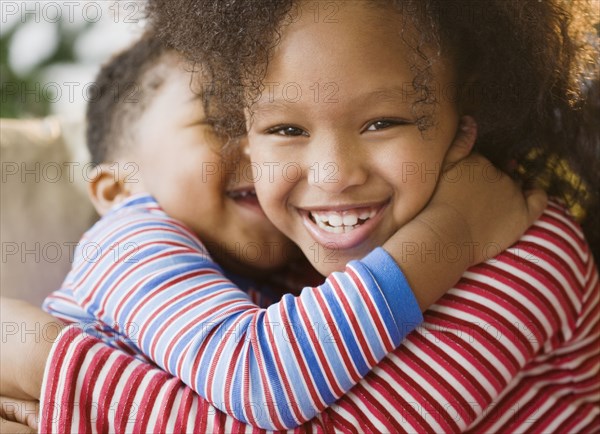 Close up of African American brother and sister hugging