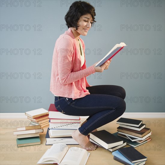 Hispanic woman reading books