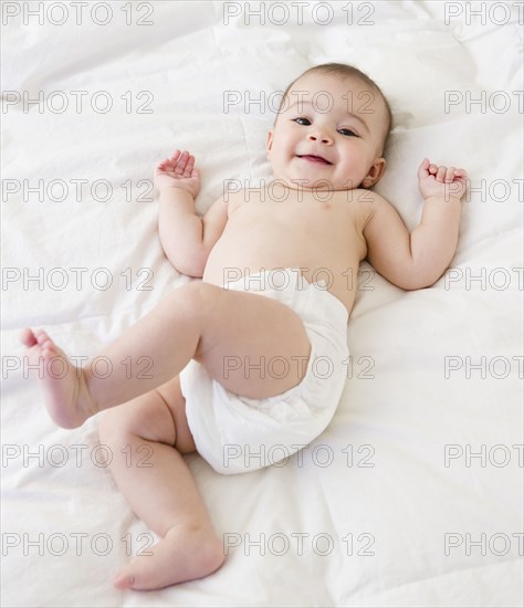 Mixed race baby laying on bed