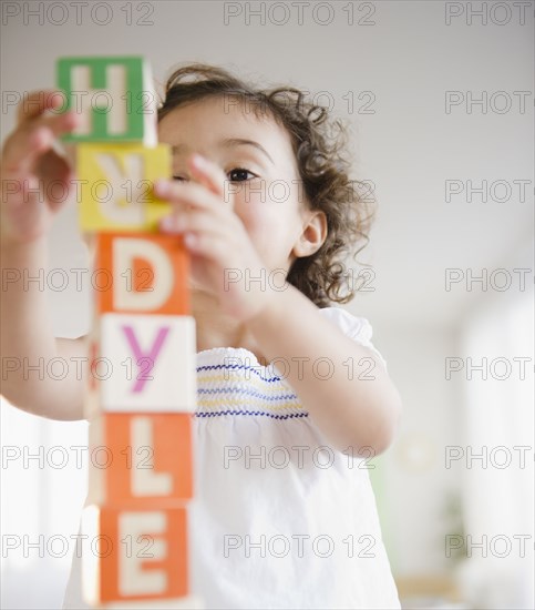 Mixed race girl stacking blocks