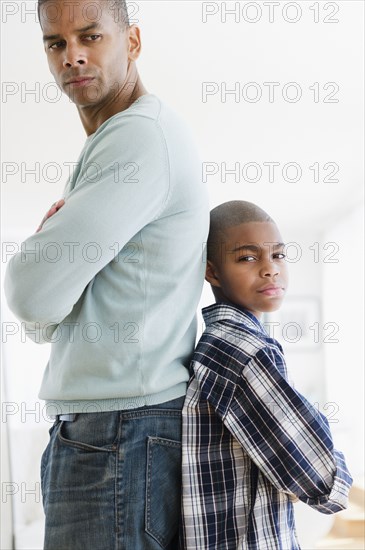 Stubborn father and son standing back to back